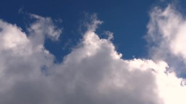 Tek yönde hareket eden beyaz bulutların zaman atlamalı. güneşli gün ve mavi arka plan.