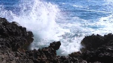 Güç dalgalar kayalar isabet. Taze deniz köpük sıçrama yavaş deniz kıyısında.
