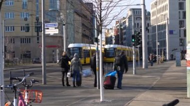 Berlin 'in merkezinde toplu taşıma kameraları ve zebra üzerinde karşıya geçen insanların görüntüleri.