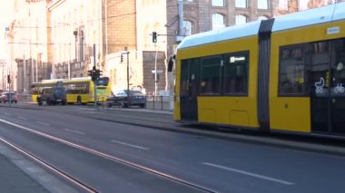 Berlin Almanya 'sında kameranın önünde giden sarı tramvayın yavaş çekim görüntüleri..