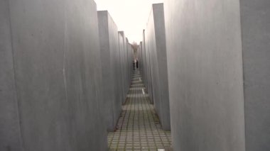 Berlin Almanya 'da öldürülen Avrupa Yahudileri Anıtı' nın içinden ağır çekimde yürüyorlar..