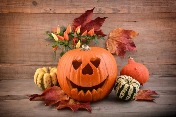 Cadılar Bayramı Balkabağı ve eski ahşap arka plan üzerinde sonbahar yaprakları.