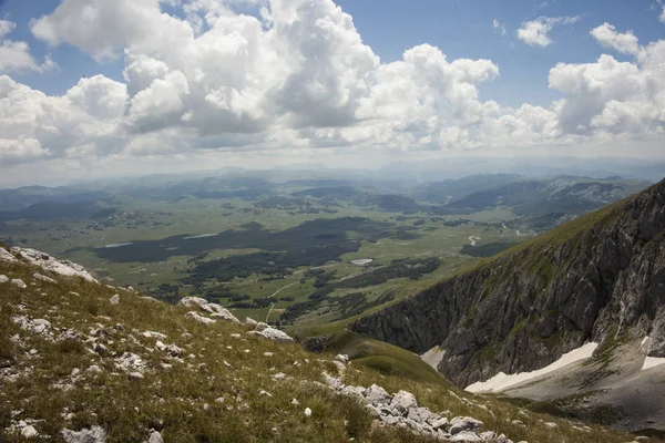 Panoramik dağ üst Sava'nın Kuk, Durmitor, Karadağ üzerinden bulutlu mavi gökyüzü altında yeşil bir vadi üzerinde