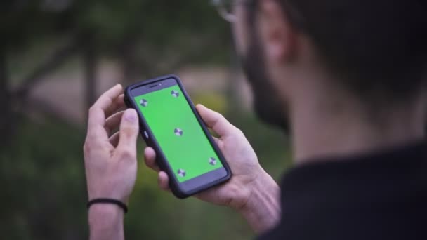 Молодой Человек Держит Смартфон Пустым Зеленым Экраном Открытом Воздухе — стоковое видео