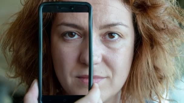 Женщина Держащая Смартфон Покрывающий Половину Лица Показывая Трансформацию После Ретуши — стоковое видео
