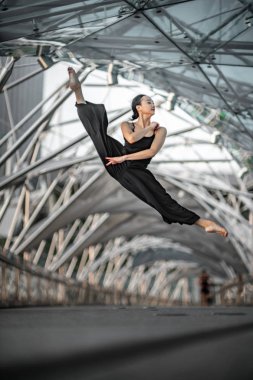 Güzel genç kız siyah giymeyi dans bir köprü