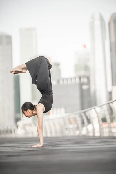 美丽的年轻女孩在城市跳舞 穿着黑色 与摩天大楼的背景 — 图库照片