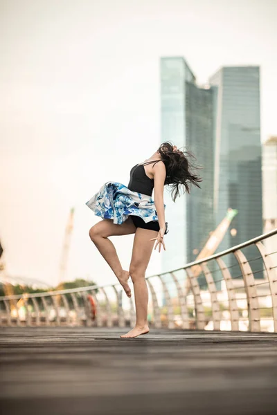 美丽的年轻女孩在城市跳舞 与摩天大楼的背景 — 图库照片