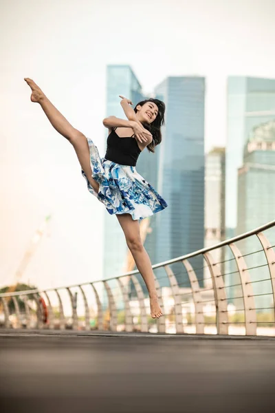 美丽的年轻女孩在城市跳舞 与摩天大楼的背景 — 图库照片