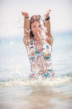 Seksi genç kız plajda denizin içinde poz 