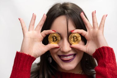 Heyecanlı gülümseyen başarılı kadın Holding Bitcoins, yatay atış onun gözlerinin önünde