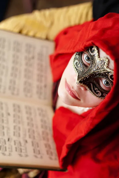 Mysterious Lady with beautiful eyes wearing a Mask, holding an ancient book of Music