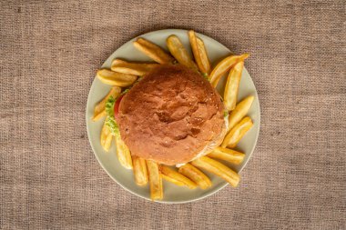 Marul, domates, kızarmış patates, lezzetli ev yapımı Hamburger bir tabakta servis