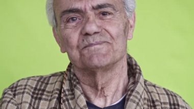 Kıdemli yaşlı adam, yakın çekim slow motion video, yeşil arka plan