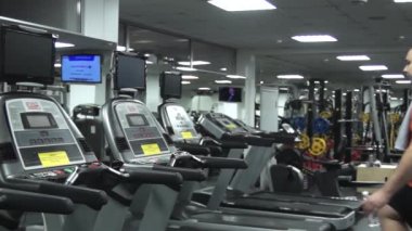 Treadnill için geliyor, onun şişe su koyarak, koşu bandında yürümeye başlayan ve başını bir havlu ile silerek şirin komik şişman adam. Sol taraftan görünüm