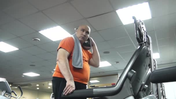 Homem Gordo Andando Esteira Limpando Cabeça Com Uma Toalha Tomando — Vídeo de Stock