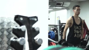 genç sporcu büyük dumbell alıyorum sonra kamera geçer için eğlenceli bir şişman adam en küçük dumbbells ile