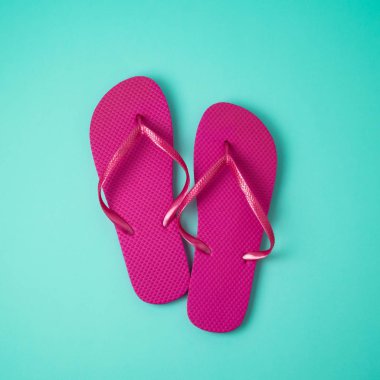 En az yaz konsepti. Mavi arka plan üzerinde pembe flip flop. Yukarıdan görüntülemek