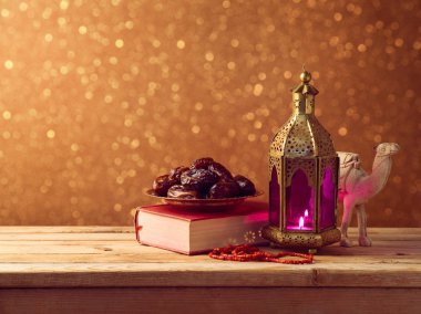 Ahşap masa bokeh arka plan üzerinde hafifleyen fener ve tarihleri meyve. Ramazan kareem tatil kutlama kavramı