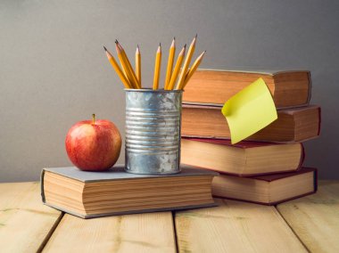 Kurşun kalem, elma ve ahşap masa üzerinde eski kitaplar ile okul kavramı geri