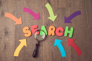 Web sitesi ve içerik Seo sıralaması kavramı ile arama. Harfler, büyüteç ve oklar ahşap arka plan üzerinde. Yukarıdan görüntülemek