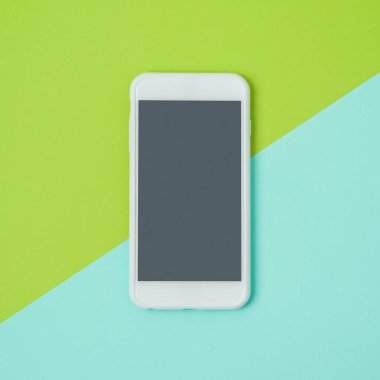 Smartphone renkli arka plan üzerinde sahte kadar. Beyaz cep telefonu en az daire yatıyordu kavramı