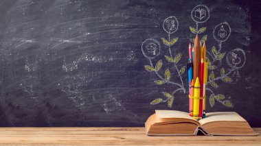 Geri Okul arka plan için kalem ve eski kitap kara tahta üzerinde yapılan eğitim ağacı