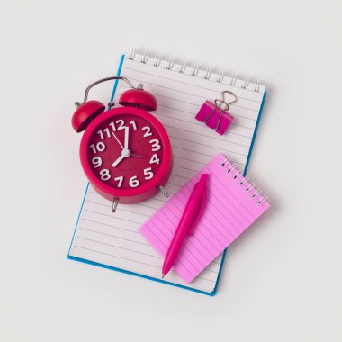 Okul kavramına defter, kalem ve çalar saat beyaz arka plan üzerinde geri. Yukarıdan görüntülemek