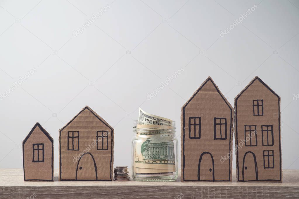 Property investment and house mortgage financial concept with money and cardboard houses