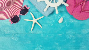 Yaz şapka, flip flop ve mavi ahşap tahta üzerinde güneş gözlüğü ile arka plan. Yukarıdan görüntüleyin. Düz yatıyordu