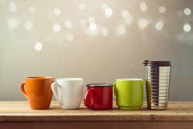 Many diifferent coffee cups on wooden table. Friendship day celebration background clipart