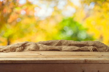 Sonbahar Doğa bokeh arka plan üzerinde çul ile boş ahşap masa 