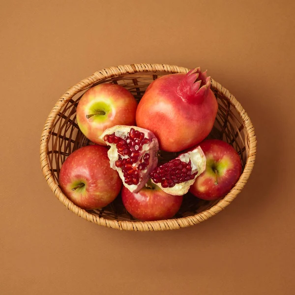 Äpfel Und Granatäpfel Korb Auf Braunem Hintergrund Minimalkonzept Flache Lage — Stockfoto