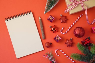 Noel tatil ve arka plan defter süsleri kırmızı masada. Üstten üstten görünüm
