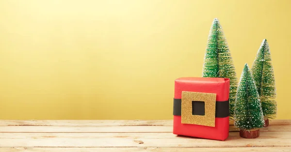 コピー スペース付きの木製テーブル サンタ ギフト ボックスと松の木装飾クリスマスの背景 — ストック写真
