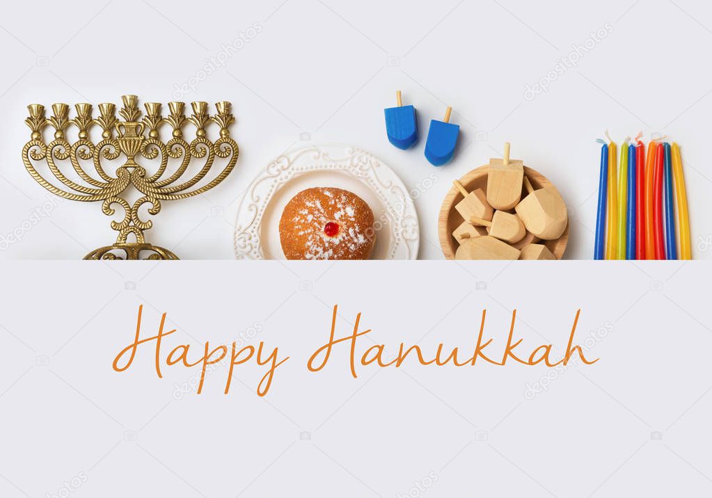 Jewish holiday Hanukkah banner design with menorah, sufganiyot and spinning tops on white background. Top view from above. Flat lay