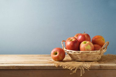 Sepeti ahşap mutfak masa arka plan üzerinde kırmızı elmalar