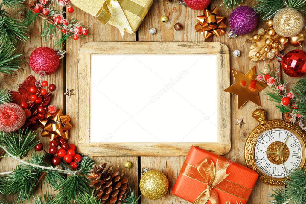 Christmas holiday background with photo frame, decorations and ornaments on wooden table. Top view from above. 