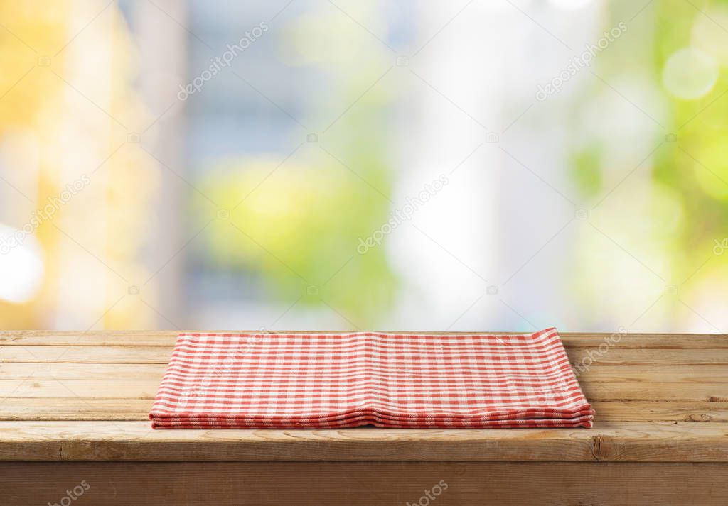 Empty wooden table with tablecloth over abstract bokeh background. Mock up for display or montage product