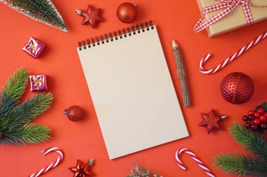 Noel tatil ve arka plan defter süsleri kırmızı masada. Üstten üstten görünüm