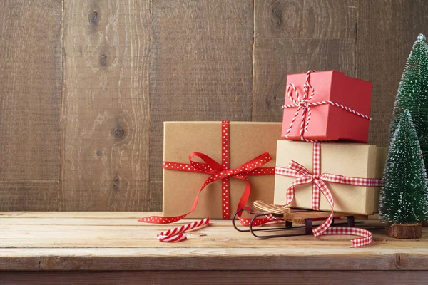 Kerstmis Achtergrond Met Geschenkdozen Slee Houten Tafel — Stockfoto