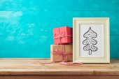 Vánoční dovolená pozadí s borovice strom kreslení a dárkové krabice na dřevěný stůl