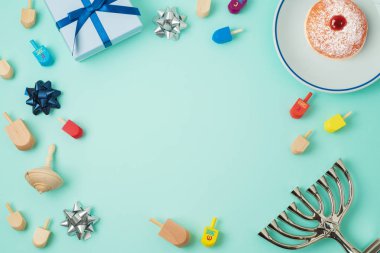 Yahudi tatil Hanukkah menorah, sufganiyot, hediye kutusu ve eğirme üstleri ile arka plan. Üstten görünüm yukarıdan. Düz yatıyordu