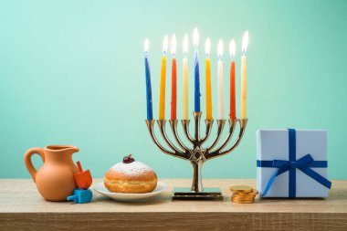 Yahudi tatil Hanukkah menorah, sufganiyot, hediye kutusu ve ahşap masa üstünde eğirme üstleri ile arka plan
