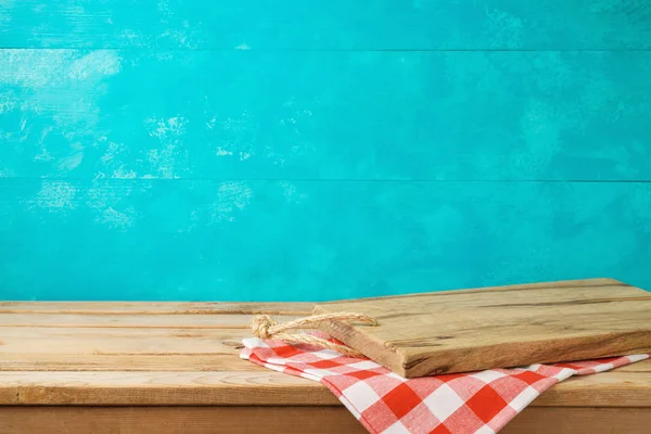 空木制切菜板在厨房桌子上与桌布在蓝色背景 — 图库照片