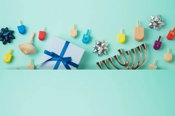 Jewish holiday Hanukkah background with menorah,  gift box and spinning tops. Top view from above. Flat lay