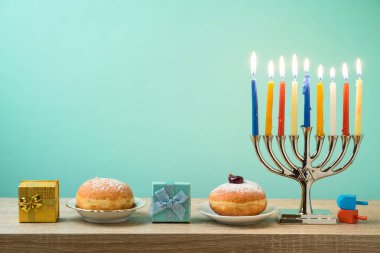 Yahudi tatil Hanukkah menorah, sufganiyot, hediye kutusu ve ahşap masa üstünde eğirme üstleri ile arka plan