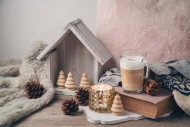 Hygge İskandinav tarzı konseptiyle latte macchiato kahve Kupası, mum ve kitap. Sıcacık kış veya Noel kompozisyon