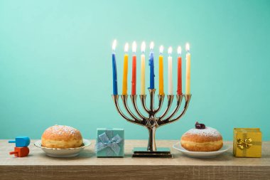 Yahudi tatil Hanukkah menorah, sufganiyot, hediye kutuları ve ahşap masa üstünde eğirme üstleri ile arka plan