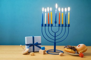 Yahudi tatil Hanukkah menorah, sufganiyot, hediye kutusu ve ahşap masa üstünde eğirme üstleri ile arka plan